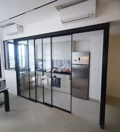 Black-framed synchronized sliding glass partition in front of a kitchen