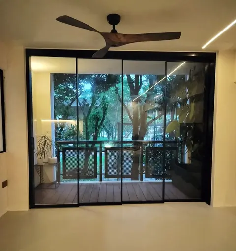 Black-framed synchronized sliding glass doors closed across a balcony opening